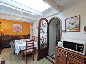 een eetkamer met een tafel en een magnetron bij Holiday Home La Congrière by Interhome in Cancale