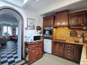 カンカルにあるHoliday Home La Congrière by Interhomeのキッチン(木製キャビネット、白い電子レンジ付)