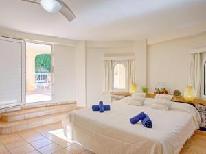 Un dormitorio con una cama grande con almohadas azules. en Villa Villa Bellevue by Interhome, en Jávea