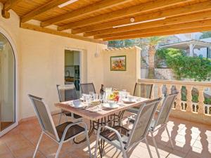 Una mesa y sillas de madera en un patio. en Villa Villa Bellevue by Interhome, en Jávea