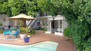 ein Haus mit Pool und Sonnenschirm in der Unterkunft Darrenwood Guesthouse & SPA in Johannesburg