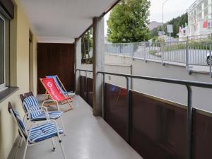 dwa krzesła siedzące na balkonie budynku w obiekcie Apartment Allod-Park-5 by Interhome w Davos