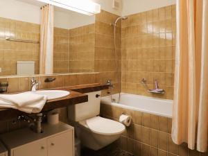 達沃斯的住宿－Apartment Allod-Park-57 by Interhome，浴室配有卫生间、盥洗盆和浴缸。