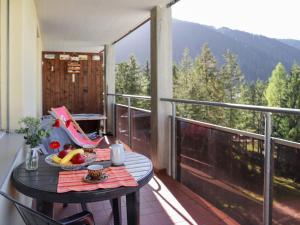 a table with a bowl of fruit on a balcony at Apartment Allod-Park-53 by Interhome in Davos