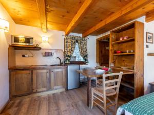 a kitchen with wooden cabinets and a table in a room at Studio Ancienne Bergerie Studio 1 - VOU140 by Interhome in Valtournenche