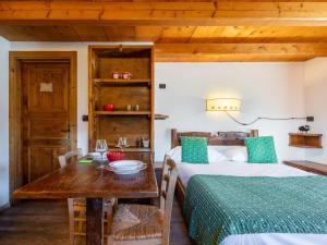 a bedroom with a bed and a wooden table at Studio Ancienne Bergerie Studio 1 - VOU140 by Interhome in Valtournenche