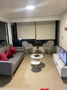 uma sala de estar com um sofá e uma televisão em Apartamento Quinto Sector em Viña del Mar