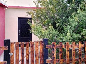 a wooden fence in front of a house with a door at Hermosa Casa en Cuatro ciénegas in Cuatrociénegas de Carranza