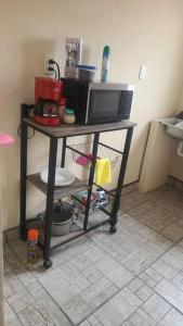 a kitchen with a table with a microwave and a tv at Hermosa Casa en Cuatro ciénegas in Cuatrociénegas de Carranza