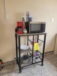 a microwave on a shelf in a kitchen at Hermosa Casa en Cuatro ciénegas in Cuatrociénegas de Carranza