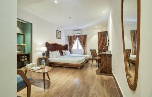 um quarto com uma cama, uma mesa e um espelho em Sky Gem Hotel - Ben Thanh em Ho Chi Minh