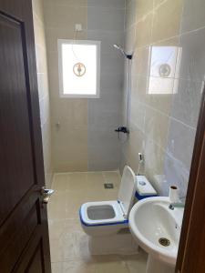 y baño con aseo y lavamanos. en Al seeb beach appartements, en Seeb