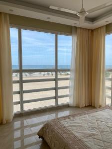 1 dormitorio con cama y vistas al océano en Al seeb beach appartements, en Seeb