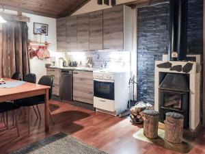 eine Küche mit einem Herd, einem Tisch und einem Kamin in der Unterkunft Holiday Home Salakolo 1 by Interhome in Ruka