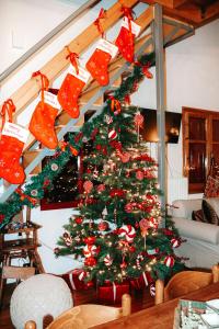 a christmas tree in a living room with christmas ornaments at PANOS PALACE in Pramanta