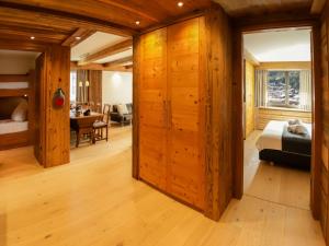 een kamer met houten wanden en een slaapkamer met een bed bij Apartment Dianthus-2 by Interhome in Zermatt