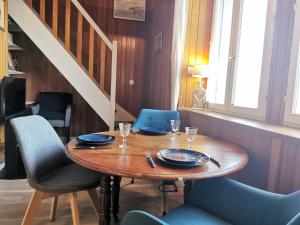 einen Holztisch in einem Zimmer mit Stühlen und einer Treppe in der Unterkunft Apartment Océan by Interhome in Saint-Malo