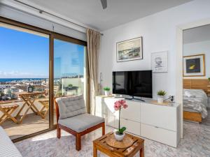 a living room with a tv and a large window at Apartment O-House by Interhome in Torremolinos