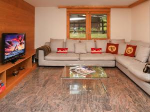 a living room with a couch and a tv at Apartment Turquino C by Interhome in Zermatt