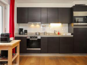 - une cuisine avec des armoires noires et une cuisinière dans l'établissement Apartment Siesta by Interhome, à Zermatt