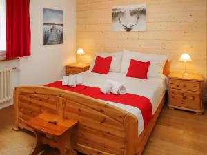 a bedroom with a large wooden bed with red pillows at Apartment Siesta by Interhome in Zermatt