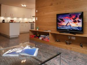 a living room with a television and a book on a table at Apartment Turquino C by Interhome in Zermatt