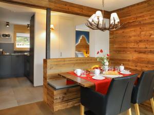 ein Esszimmer mit einem Holztisch und einem roten Tischtuch in der Unterkunft Apartment Papillon by Interhome in Zermatt