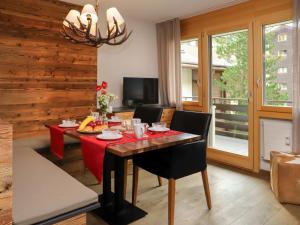 ein Esszimmer mit einem roten Tisch und Stühlen in der Unterkunft Apartment Papillon by Interhome in Zermatt