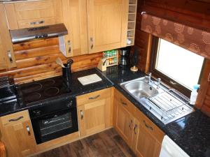 a small kitchen with a sink and a stove at Chalet Highand Lodges-1 by Interhome in Spean Bridge