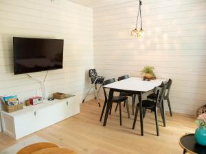 a dining room with a table and chairs and a tv at Holiday Home Kasnäs marina c 22 by Interhome in Kasnäs
