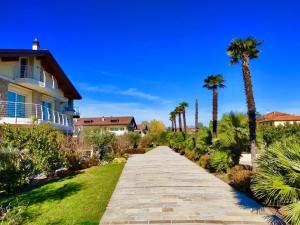 una pasarela que conduce a una casa con palmeras en Villa RELAX, en Sirmione