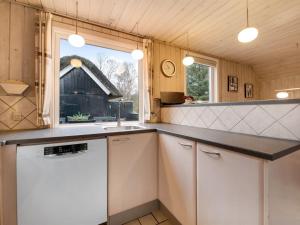 une cuisine avec un comptoir, un évier et une fenêtre dans l'établissement Holiday Home Patrik - 1-4km from the sea in Western Jutland by Interhome, à Blåvand