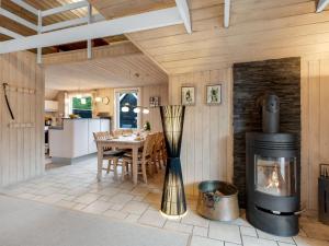 - un salon avec une cheminée et une table dans l'établissement Holiday Home Patrik - 1-4km from the sea in Western Jutland by Interhome, à Blåvand
