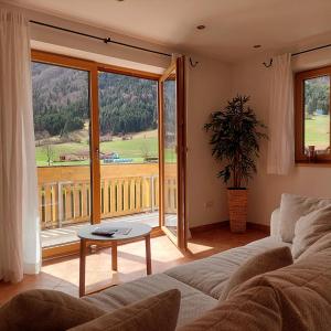 uma sala de estar com um sofá e uma grande janela em Apartment Kofelblick em Unterammergau