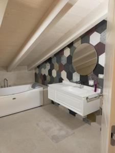 Un baño con lavabo, espejo y bañera. en Villa RELAX, en Sirmione