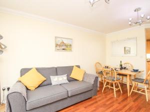 a living room with a couch and a table at Sandy Haven in Swanage