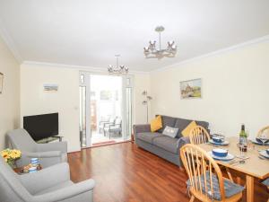 a living room with a couch and a table at Sandy Haven in Swanage