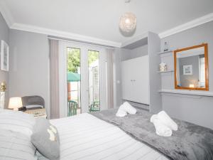 a bedroom with a bed with a mirror and a window at Sandy Haven in Swanage