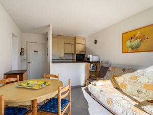 uma sala de estar com uma mesa e um sofá em Apartment Les Pescadieres-3 by Interhome em Le Lavandou