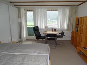 1 dormitorio con 1 cama, mesa y sillas en Apartment Parkweg 9-602 by Interhome en Engelberg