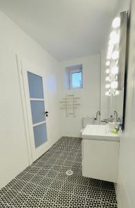 bagno bianco con lavandino e specchio di BioLocalia House Dobrogea a Baloteşti
