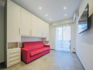 ein rotes Sofa im Wohnzimmer mit Fenster in der Unterkunft Studio Rosso by Interhome in Rapallo