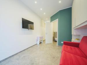 ein Wohnzimmer mit einem roten Sofa und einem TV in der Unterkunft Studio Rosso by Interhome in Rapallo