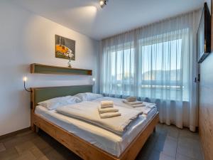 ein Schlafzimmer mit einem Bett und einem großen Fenster in der Unterkunft Apartment Verditz alpe maritima Ski & See - Top 1 by Interhome in Annenheim