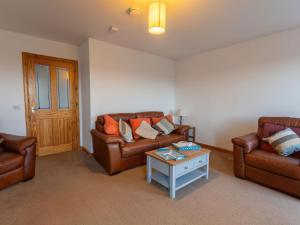 una sala de estar con 2 sofás de cuero y una mesa. en Holiday Home Shedfield by Interhome en Drumnadrochit