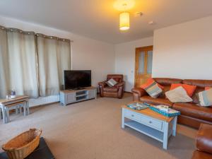 a living room with a couch and a tv at Holiday Home Shedfield by Interhome in Drumnadrochit
