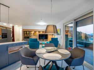 a kitchen and living room with a table and chairs at Apartment Adlerblick alpe maritima Ski & See - 22 by Interhome in Annenheim