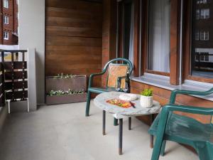 una mesa y sillas en un porche con una pizza en Apartment Pasadena-3 by Interhome en Zermatt