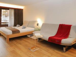 Un dormitorio con una cama, un sofá y una silla. en Apartment Pasadena-3 by Interhome, en Zermatt 22 fotos más