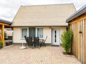 eine Terrasse mit Stühlen und einem Tisch vor einem Haus in der Unterkunft Holiday Home Fischerbungalow by Interhome in Zempin